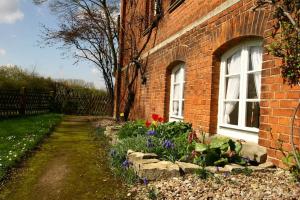 a brick house with two windows and some flowers at Idyllische Ferienwohnung auf altem Bauernhof in Emmerthal