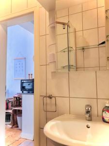 a bathroom with a sink and a tv on the wall at Idyllische Ferienwohnung auf altem Bauernhof in Emmerthal