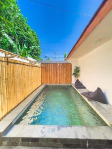 - une piscine dans un jardin avec une clôture en bois dans l'établissement OsOs Paviliun, à Timuran