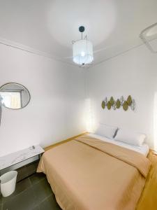 a white room with a bed and a mirror at OsOs Paviliun in Yogyakarta
