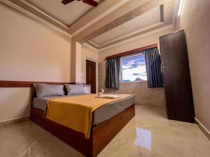 a bedroom with a bed and a large window at Green Palace Resort in Vagamon