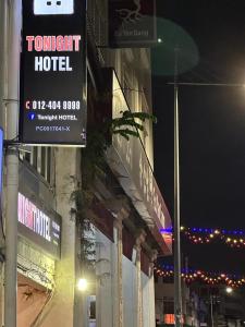 a hotel sign on the side of a building at night at Tonight Hotel in George Town