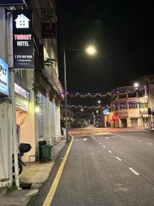 an empty street at night with a street light and buildings at Tonight Hotel in George Town