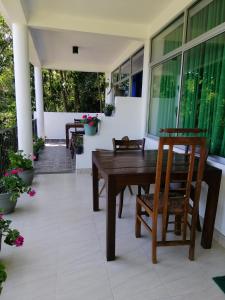 a wooden table and chairs on a porch with flowers at Super View in Ella