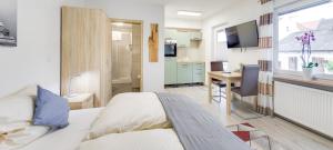 sypialnia z łóżkiem oraz kuchnia z biurkiem w obiekcie Weisses Rössl w mieście Pfreimd
