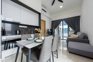 eine Küche und ein Wohnzimmer mit einem Tisch und Stühlen in der Unterkunft The Colony and The Luxe Premier Suites Kuala Lumpur in Kuala Lumpur