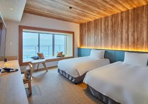 Minatogawaにある ホテルアラクージュオキナワのベッド2台と窓が備わるホテルルームです。