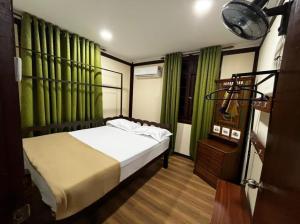 a bedroom with a bed and green curtains at Inap Nekmi Kuala Terengganu With Pool in Kuala Terengganu
