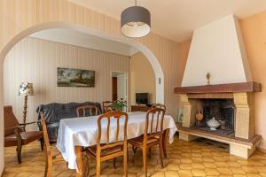a dining room with a table and a fireplace at L'Arriga - Maison pour 6 personnes in Gradignan