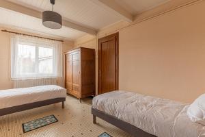 a bedroom with two beds and a cabinet and a window at L'Arriga - Maison pour 6 personnes in Gradignan