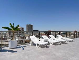 een rij witte ligstoelen op een dak bij Courtyard Long Beach Holiday Resort in Iskele