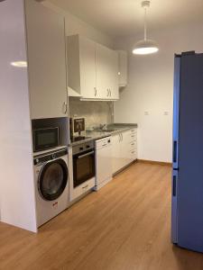 eine Küche mit einer Waschmaschine und einer Waschmaschine in der Unterkunft Júlio de Matos Guest House in Porto