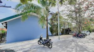 un groupe de motocycles garés à côté d'un bâtiment bleu dans l'établissement RedDoorz near Universitas Palangkaraya 3, à Palangka Raya