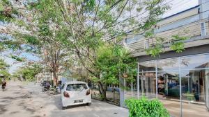 a small white car parked in front of a building at RedDoorz near Universitas Palangkaraya 3 in Palangkaraya +2 photos