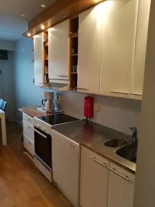 een keuken met witte kasten en een wastafel bij Spacious super located Lahti apartment in Lahti