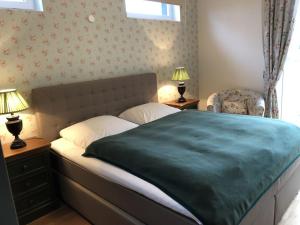 Un dormitorio con una cama con una manta verde. en Ferienwohnung auf Gut Owstin, en Owstin