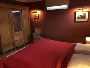 Un dormitorio con una cama con una manta roja. en Ferienwohnung auf Gut Owstin, en Owstin