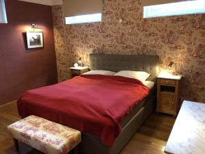 a bedroom with a large bed with a red blanket at Ferienwohnung auf Gut Owstin in Owstin