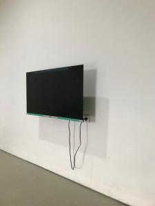 a flat screen tv hanging on a white wall at Yayah Hostel in Bogor