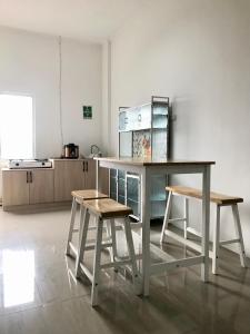 a kitchen with a table and two stools at Yayah Hostel in Bogor