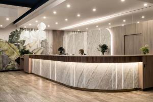 a woman sitting at a counter in a lobby at Hotel Astor in Jastrzębia Góra