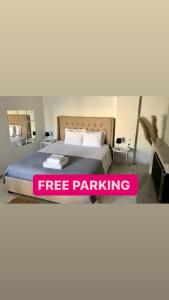 a bedroom with a bed with a free parking sign on it at Greece Apartments Now in Patra
