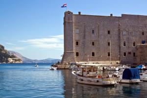 a group of boats in the water in front of a castle at Apartment NAVA - new and spacious gem - FREE PARKING in Dubrovnik