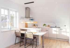a kitchen with a table and chairs and a sink at Ferienwohnung 54 Nord in Nebel