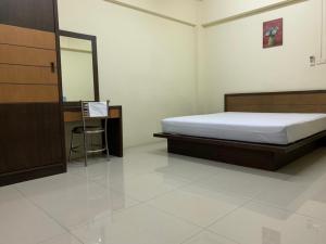 a bedroom with a bed and a desk and a mirror at เขมกานต์ อพาร์ตเมนต์ in Ban Hua Thong Lang