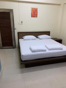 a bed with white sheets and pillows in a room at เขมกานต์ อพาร์ตเมนต์ in Ban Hua Thong Lang