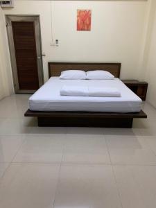 a bed in a bedroom with a white floor at เขมกานต์ อพาร์ตเมนต์ in Ban Hua Thong Lang