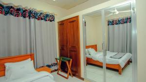 1 Schlafzimmer mit 2 Betten und einem Spiegel in der Unterkunft La Casa Preciosa in Tanga