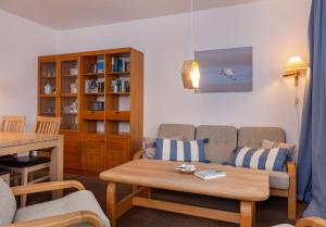ein Wohnzimmer mit einem Sofa und einem Tisch in der Unterkunft Haus am Seezeichen - Whg. Lürßen in Wittdün