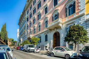 een gebouw met auto's geparkeerd aan de kant van een straat bij Operà Suites Pinciana in Rome