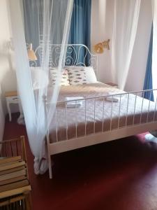 ein Bett mit weißen Vorhängen in einem Schlafzimmer in der Unterkunft Two-bedroom apartment with sea view in Stari Grad
