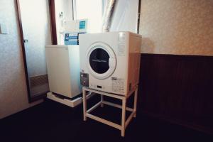 a washing machine on a stand in a room at Hotel New Moustache in Shizuoka