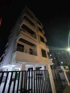 ein hohes weißes Gebäude mit Balkon in der Nacht in der Unterkunft SPOT ON Hotel The Annie in Bilāspur
