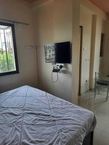 Schlafzimmer mit einem Bett und einem Flachbild-TV in der Unterkunft SPOT ON Hotel The Annie in Bilāspur