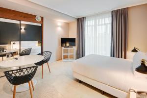 Habitación de hotel con cama, mesa y sillas en Sercotel Togumar en Madrid