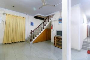 a living room with a staircase and a television at RedDoorz Plus near WTC Batanghari Mall in Tanjungjohor