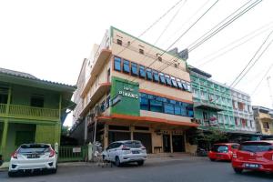un edificio con coches estacionados frente a él en RedDoorz Plus near WTC Batanghari Mall, en Tanjungjohor