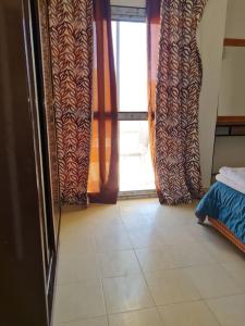 Camera con tende e pavimento piastrellato. di basic 2 bedroom apartment a Sharm El Sheikh