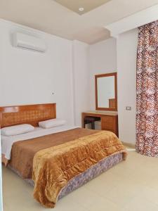 una camera con letto, scrivania e specchio di basic 2 bedroom apartment a Sharm El Sheikh