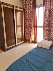 una camera con un letto blu e una finestra di basic 2 bedroom apartment a Sharm El Sheikh