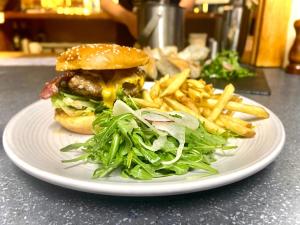 un plato con una hamburguesa y papas fritas en una mesa en Inversnaid Bunkhouse en Inversnaid