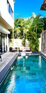 - une piscine avec deux bancs à côté d'un bâtiment dans l'établissement Villa Hacienda 4, à Cap Malheureux