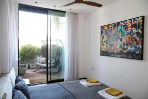 ein Schlafzimmer mit einem Bett und einem Wandgemälde in der Unterkunft 4BDR - Stunning & Magnificent Duplex Penthouse TLV in Tel Aviv