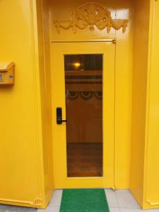 首爾的住宿－Seoul Guesthouse Foreigners Only，一间房间里一扇黄色的门,上面有绿色地毯