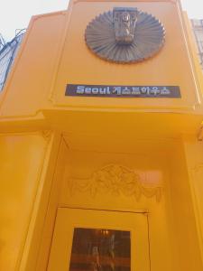 首爾的住宿－Seoul Guesthouse Foreigners Only，门上标有标志的黄色建筑