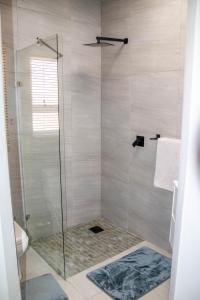 a bathroom with a shower with a glass door at Ongwe Leisure Property in Swakopmund